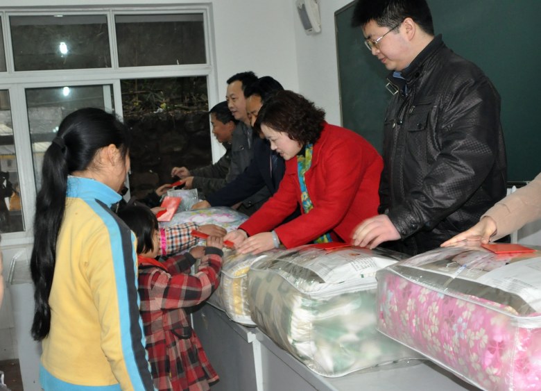 龙门乡捐赠活动为六名贫困生发放棉被和慰问金